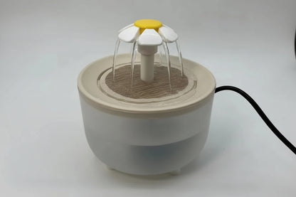 Small white device with a yellow flower-like top on a light gray background