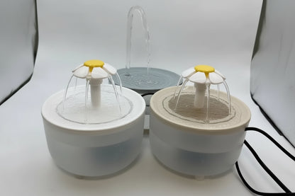 Two pet water fountains with floral designs on a white background