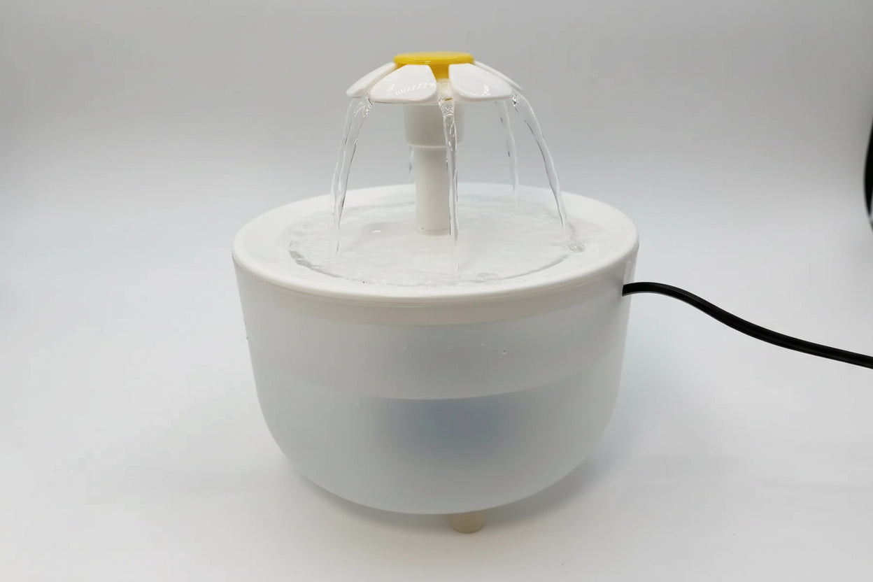 Small white fountain with water feature on a light gray background