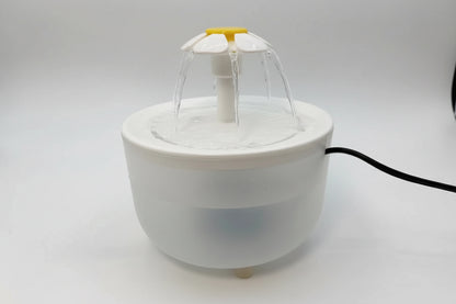 Small white fountain with water feature on a light gray background