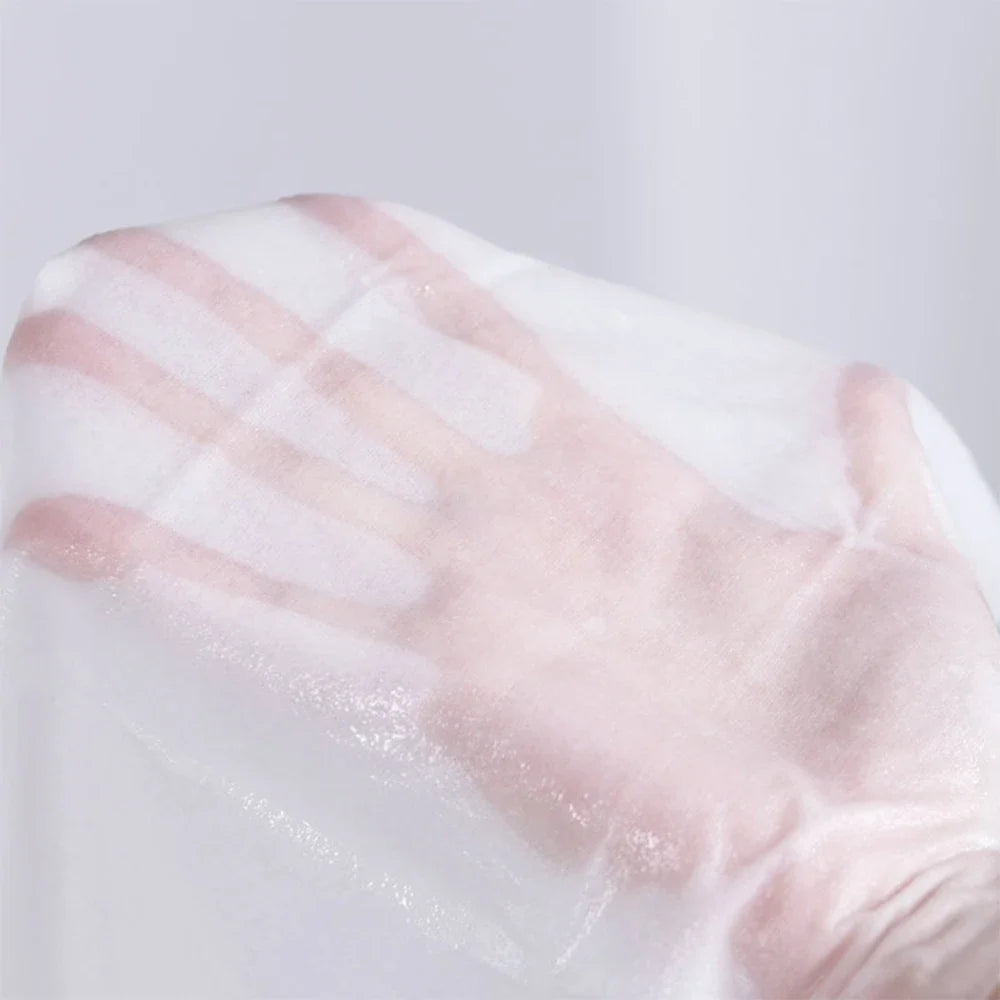 Close-up of a hand wearing a transparent glove with pink stripes on a light gray background